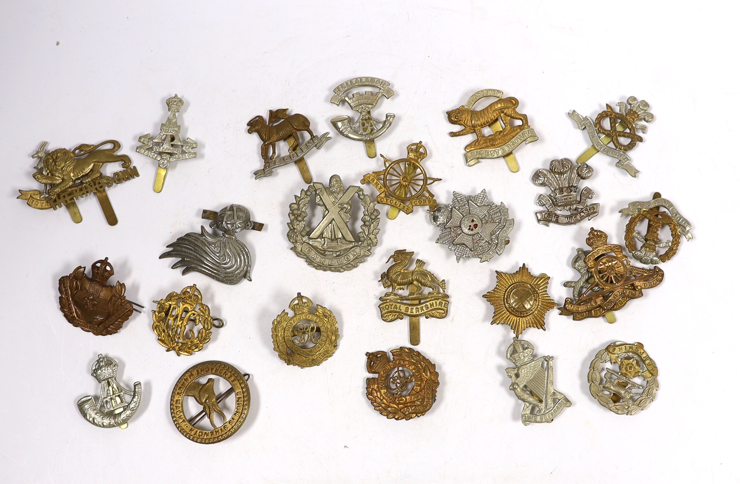 Twenty-five military cap badges including Royal Engineers, The Kings Own, Royal Warwickshire, North Stafford, Royal Berkshire, The Border Regiment, Army Cyclist Corps, South Staffordshire, Middlesex, Cameron, Hampshire,